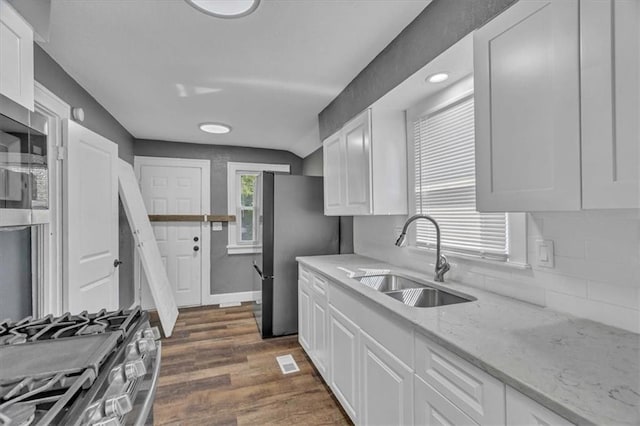 kitchen with white cabinetry, sink, light stone countertops, and appliances with stainless steel finishes