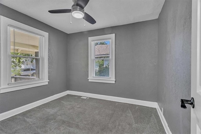 unfurnished room with carpet floors, a wealth of natural light, and ceiling fan