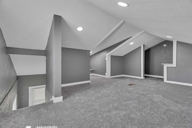 bonus room with carpet floors, vaulted ceiling, and a textured ceiling