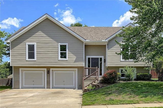 bi-level home with a garage and a front lawn