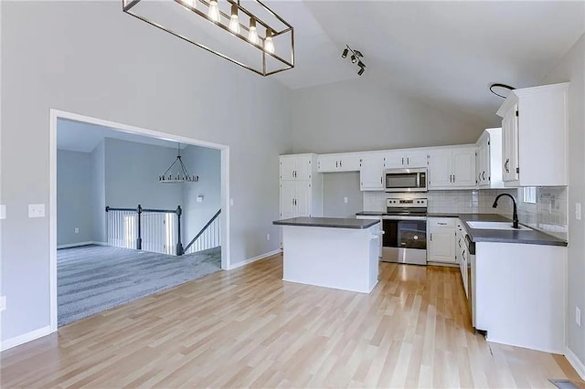 kitchen featuring sink, a center island, pendant lighting, stainless steel appliances, and white cabinets