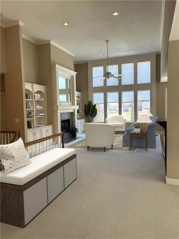 living room featuring a high end fireplace, carpet floors, ornamental molding, recessed lighting, and a ceiling fan