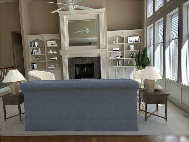 living room featuring visible vents, a ceiling fan, wood finished floors, and a fireplace