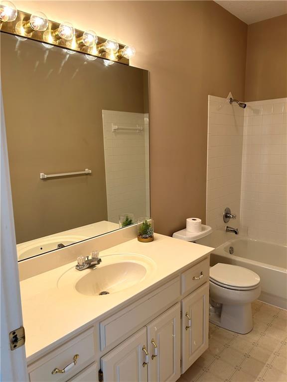 bathroom featuring toilet, tub / shower combination, and vanity