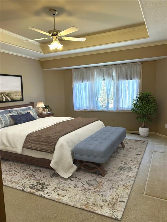 carpeted bedroom with ceiling fan, baseboards, a raised ceiling, and ornamental molding