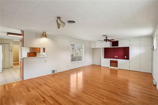 unfurnished living room featuring a ceiling fan and light wood-style flooring