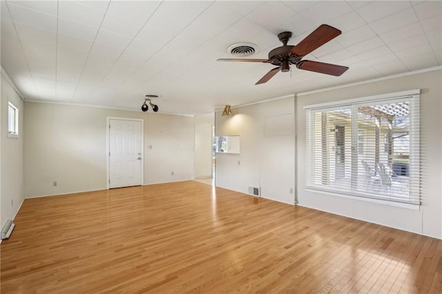 spare room featuring light wood-type flooring, plenty of natural light, a ceiling fan, and ornamental molding