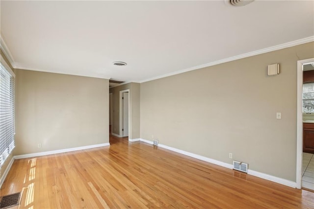 unfurnished room featuring light wood-type flooring, baseboards, plenty of natural light, and crown molding
