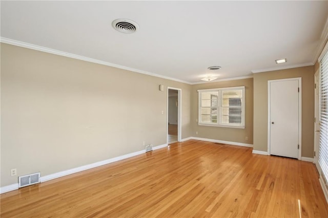 spare room with baseboards, ornamental molding, and light wood-style flooring