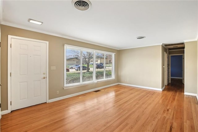 unfurnished living room with baseboards, ornamental molding, and light wood-style flooring