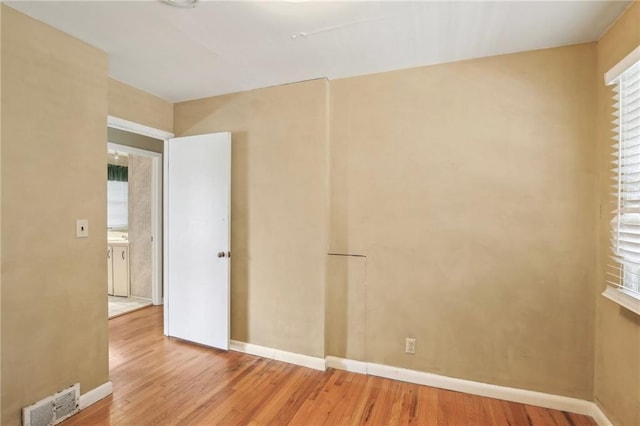 spare room featuring wood finished floors and baseboards