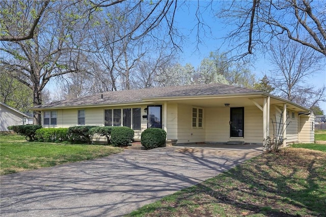 single story home featuring asphalt driveway, a front yard, and an attached carport