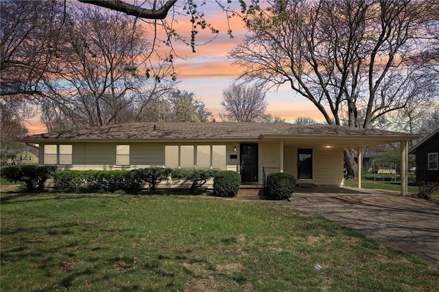 view of front of house with driveway, a front yard, and an attached carport