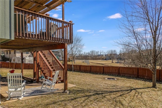 view of yard with fence, a patio, a wooden deck, and stairs