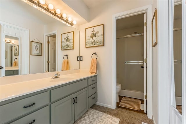 full bath with toilet, a shower stall, baseboards, and vanity