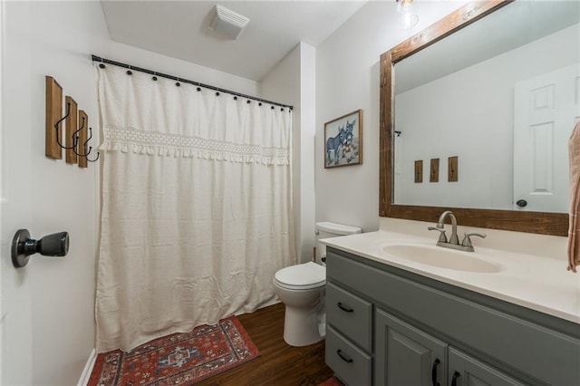 full bath featuring curtained shower, toilet, wood finished floors, vanity, and visible vents