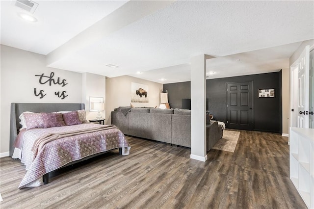 bedroom with dark wood finished floors, visible vents, and baseboards