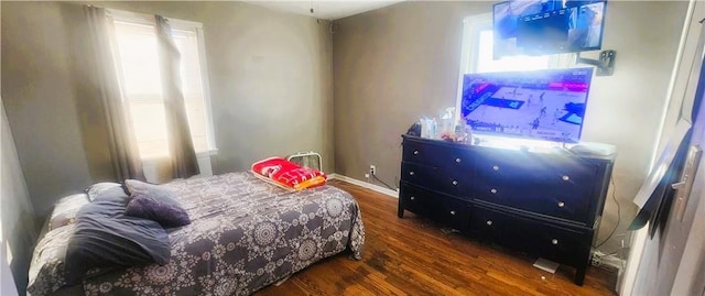 bedroom with dark hardwood / wood-style flooring