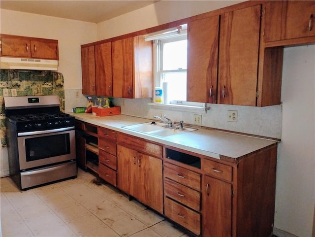 kitchen with sink, decorative backsplash, and stainless steel range with gas cooktop