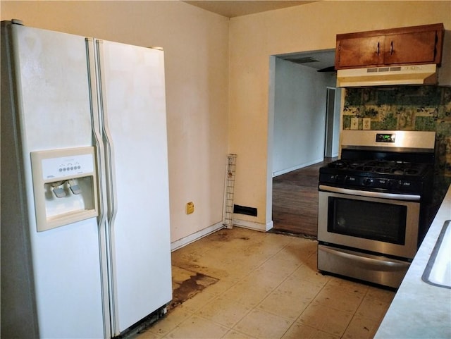 kitchen featuring gas range and white fridge with ice dispenser