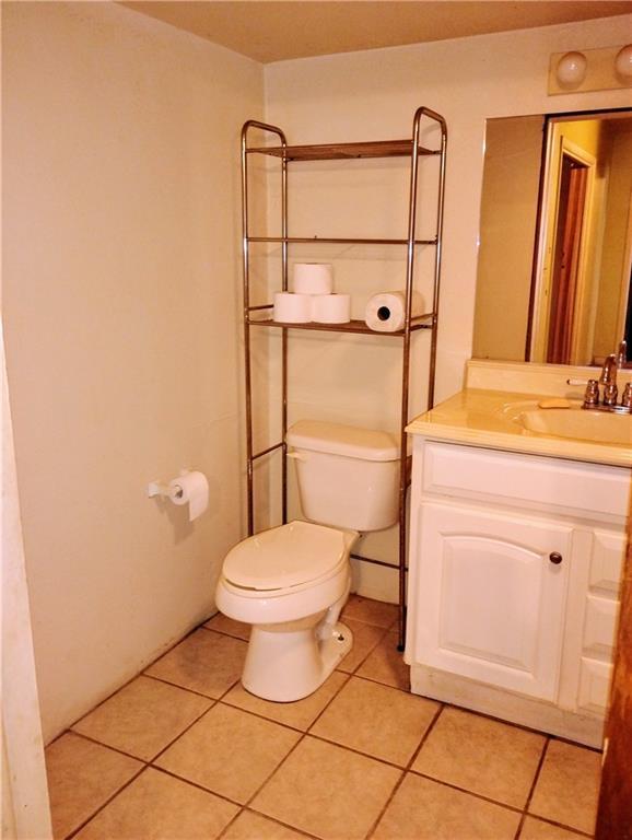 bathroom featuring vanity, tile patterned floors, and toilet