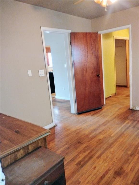 empty room with ceiling fan and light wood-type flooring