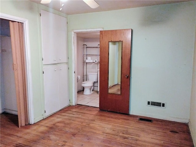 interior space featuring ensuite bath and light wood-type flooring