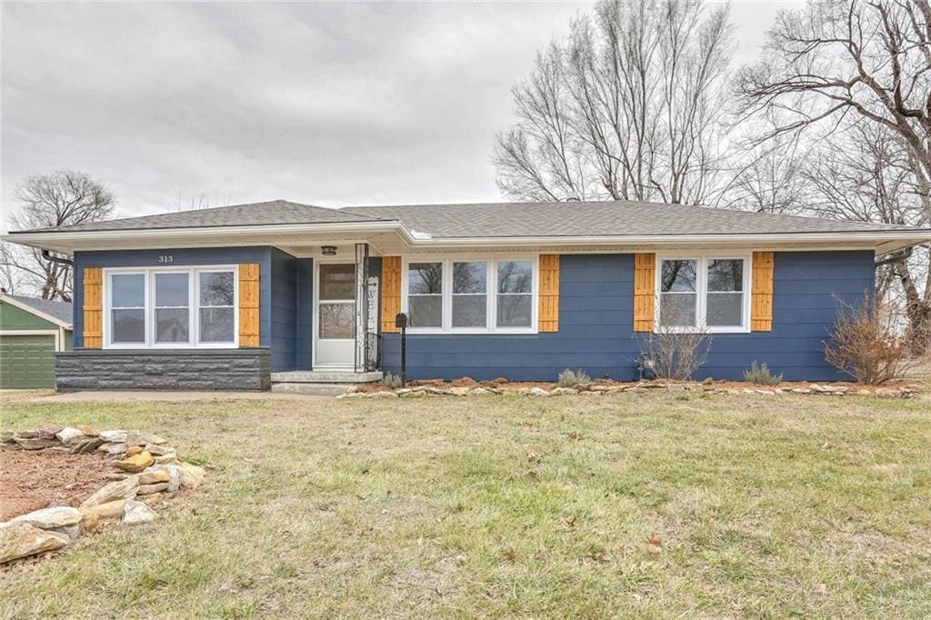 single story home featuring a garage and a front yard