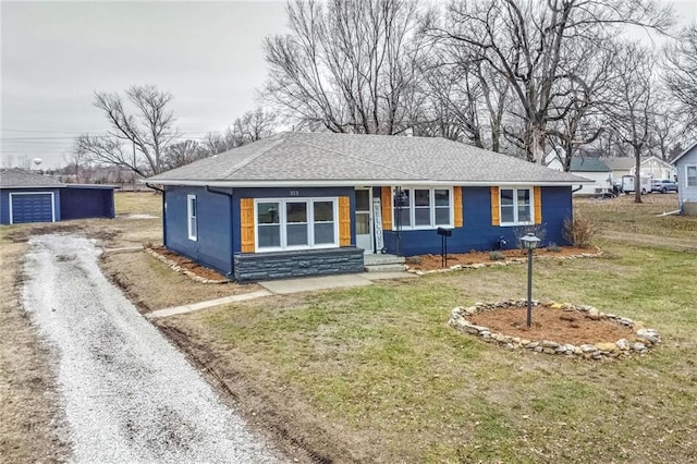 single story home with an outbuilding, a garage, and a front yard