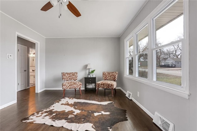 living area with crown molding, ceiling fan, and dark hardwood / wood-style flooring