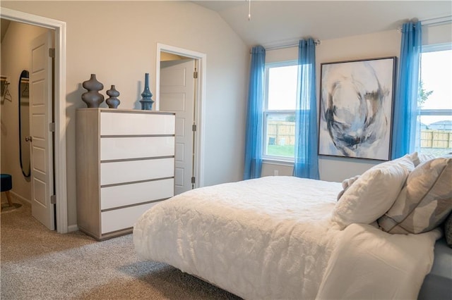 carpeted bedroom featuring multiple windows and vaulted ceiling