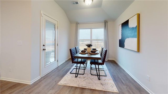 dining area with lofted ceiling and hardwood / wood-style floors