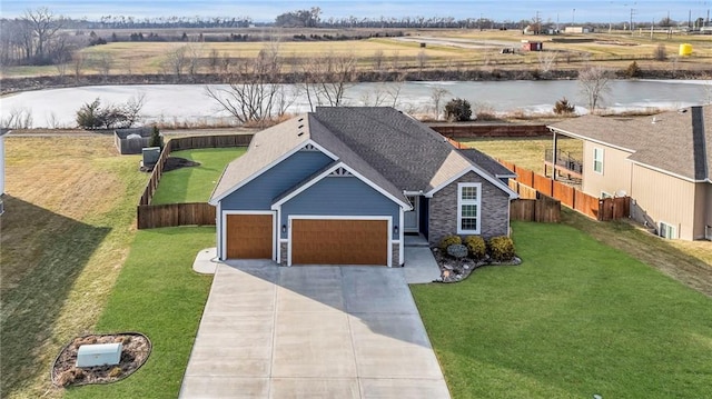 view of front facade with a garage, a water view, and a front lawn