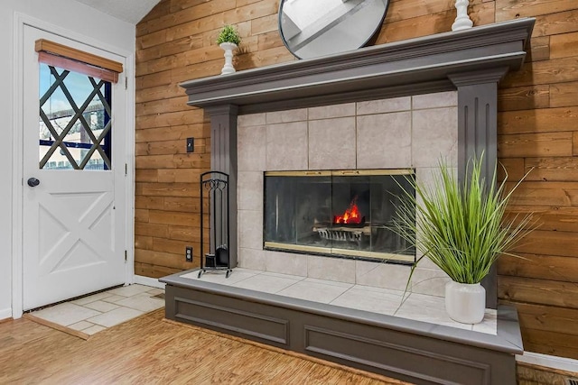 room details featuring a tile fireplace and wooden walls