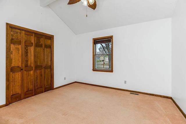 unfurnished bedroom with ceiling fan, carpet flooring, high vaulted ceiling, and beam ceiling