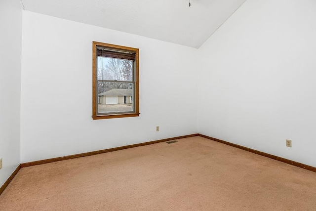 unfurnished room featuring vaulted ceiling and carpet floors