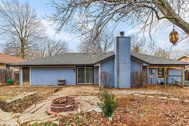 rear view of property with a fire pit