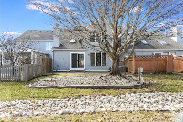 rear view of property with fence private yard, roof with shingles, and stucco siding