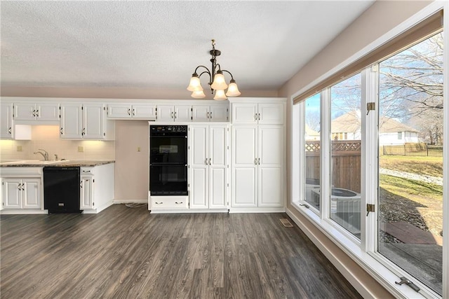 kitchen with a sink, white cabinetry, light countertops, dark wood-style floors, and black appliances