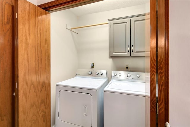 washroom featuring washing machine and dryer and cabinet space