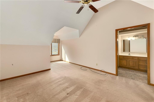 additional living space with light carpet, baseboards, a ceiling fan, vaulted ceiling, and a sink