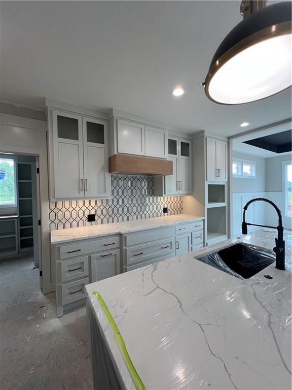 2209 W 176th Pl, Overland Park, KS 66085 - kitchen with a sink, tasteful backsplash, light stone countertops, healthy amount of natural light, and recessed lighting