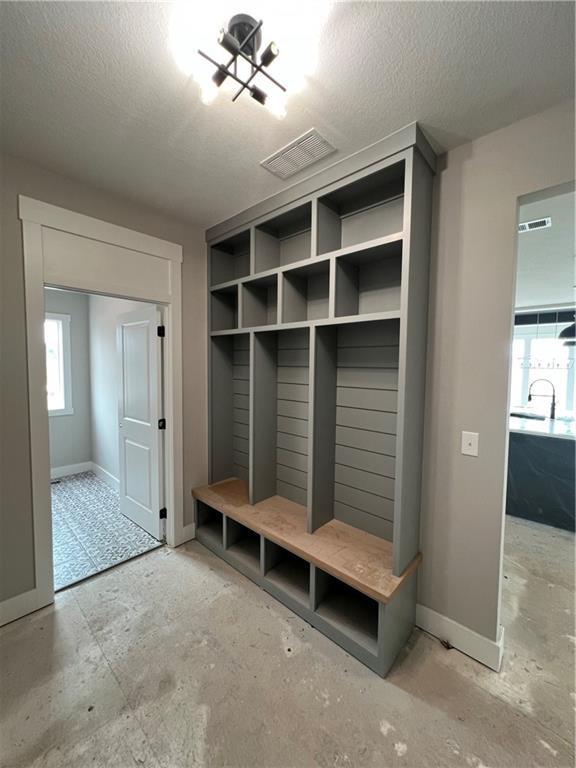 2209 W 176th Pl, Overland Park, KS 66085 - mudroom with a textured ceiling, baseboards, and a sink