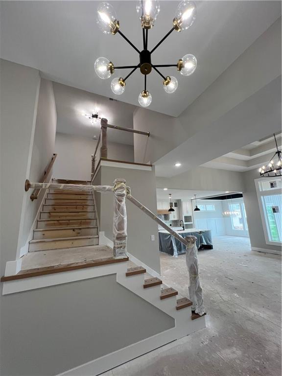 2209 W 176th Pl, Overland Park, KS 66085 - stairway featuring a chandelier and unfinished concrete floors