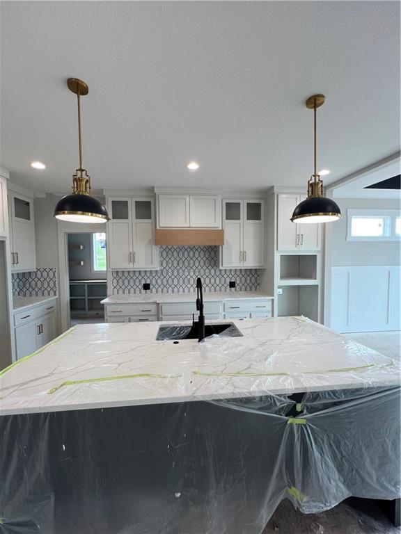 2209 W 176th Pl, Overland Park, KS 66085 - kitchen with a sink, tasteful backsplash, glass insert cabinets, white cabinets, and recessed lighting