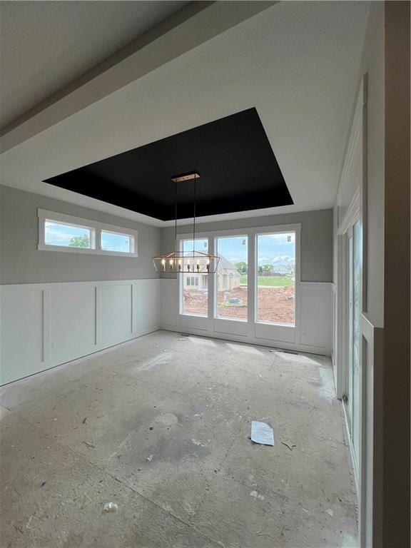 2209 W 176th Pl, Overland Park, KS 66085 - unfurnished dining area featuring a tray ceiling, plenty of natural light, a chandelier, and wainscoting