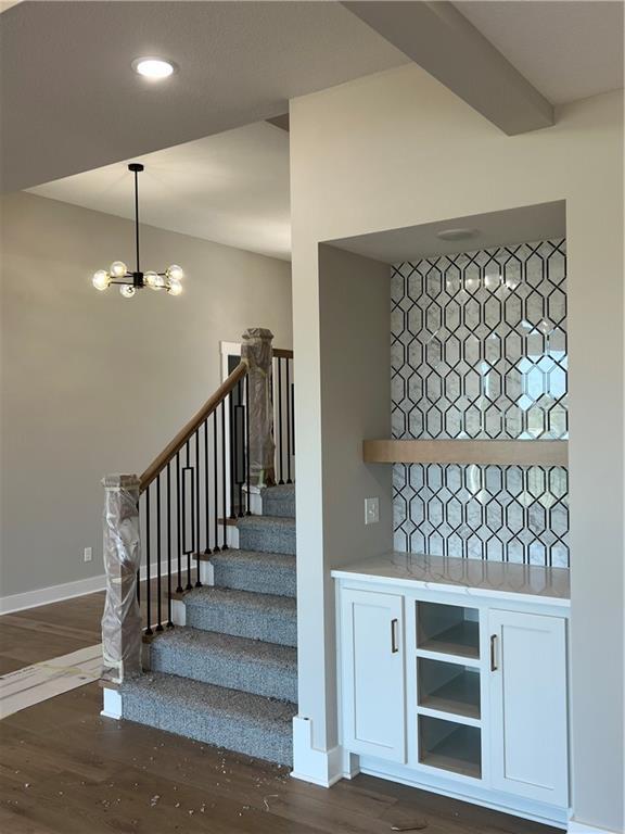 2209 W 176th Pl, Overland Park, KS 66085 - stairs featuring wood finished floors and a chandelier
