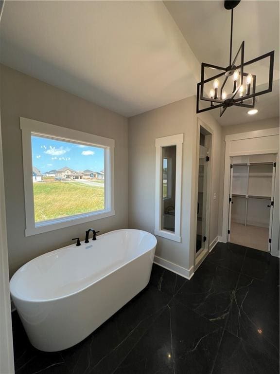 2209 W 176th Pl, Overland Park, KS 66085 - full bath featuring a freestanding tub, a walk in closet, a chandelier, marble finish flooring, and a stall shower