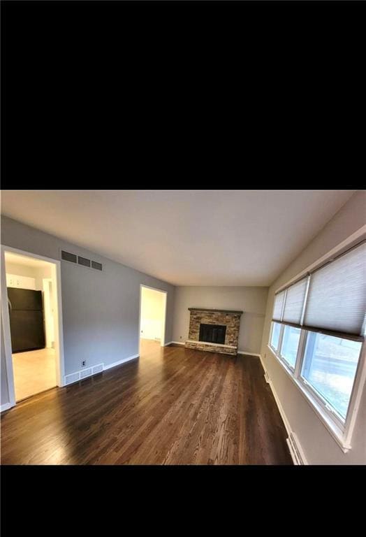 unfurnished living room with a fireplace and dark hardwood / wood-style floors