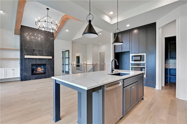 24909 W 98th Pl, Lenexa, KS 66227 - kitchen featuring stainless steel appliances, light wood-style flooring, open floor plan, a chandelier, and a center island with sink